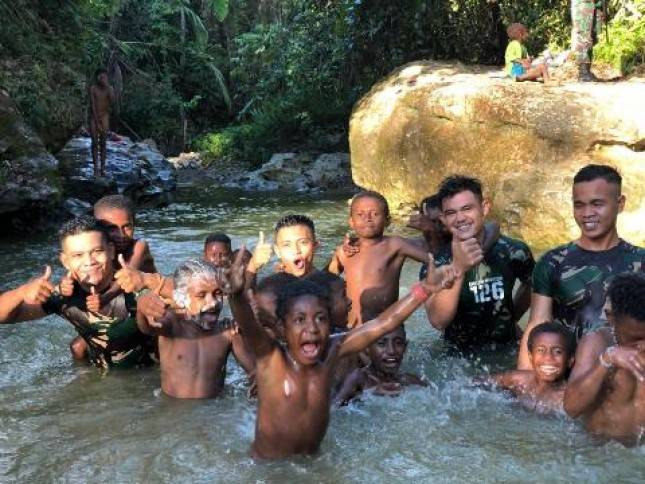 Personel Satgas Yonif 126 KC Bermain Bersama Ajak Anak-Anak di  Sungai