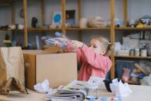 Young girl recycling plastic bottles in an organized classroom environment. (Foto: Anna Shvets / Pexels)